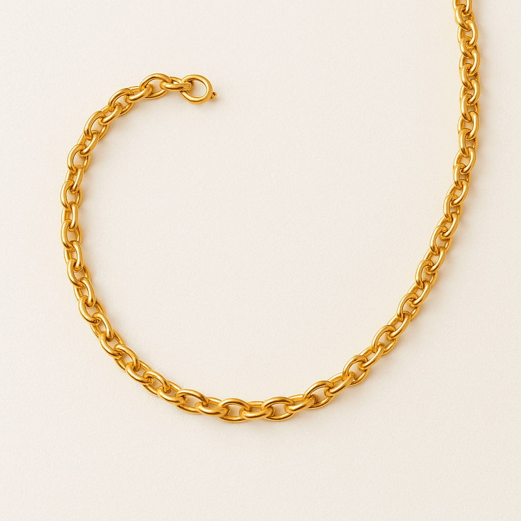 Close-up of a gold chain necklace on a neutral backdrop.