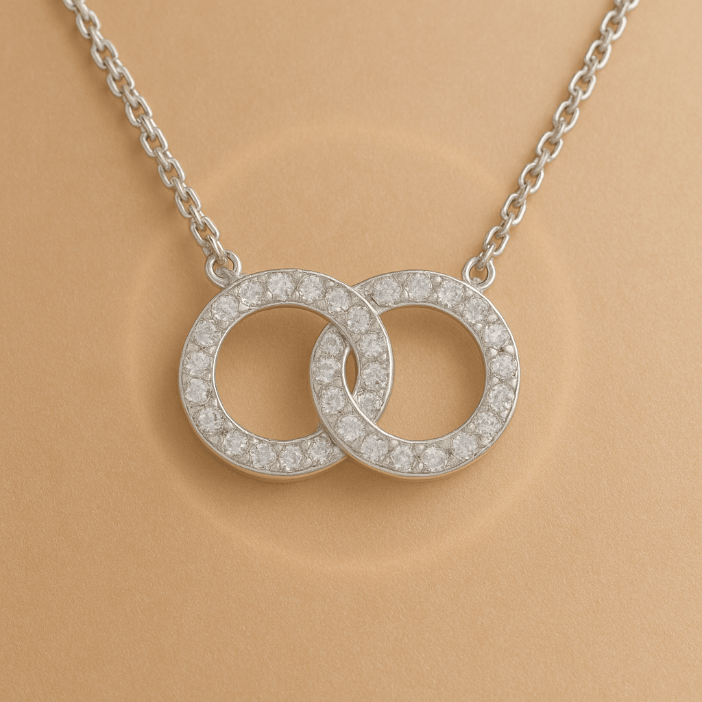Silver necklace with two overlapping diamond-studded circles.
